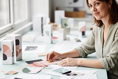 Anna Meier arbeitet in einem hellen Designstudio an einem Branding-Entwurf